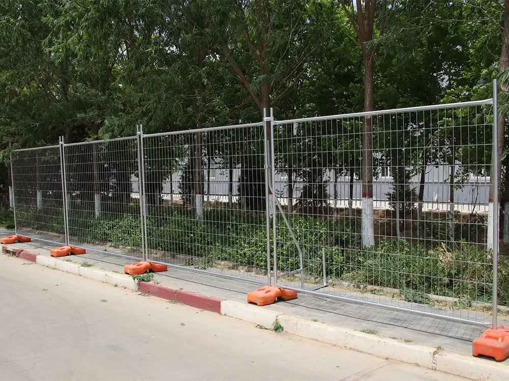Temporary welded mesh fence on weighted bases beside a road