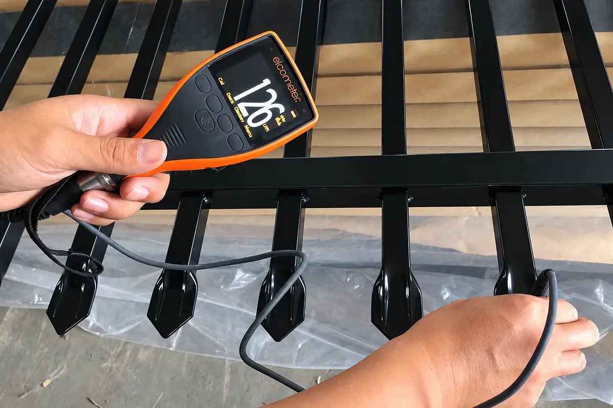 Handheld coating gauge checking black steel fence components