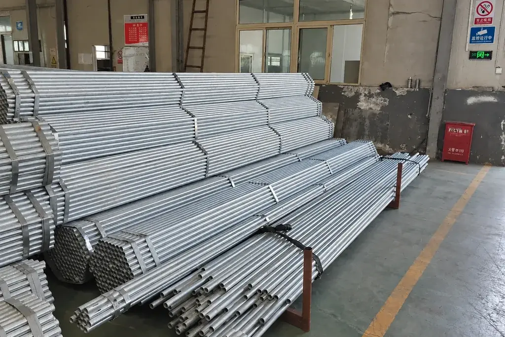 Bundles of galvanised steel tubes stored inside a workshop