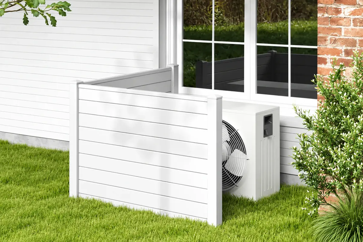 Small white vinyl privacy screen enclosing outdoor equipment beside a house