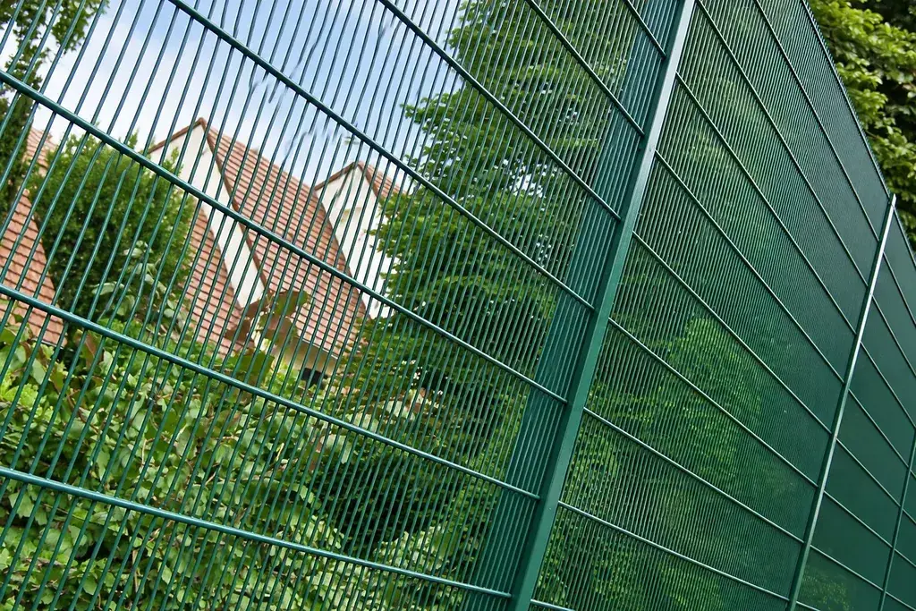 Green welded mesh panels meeting at a fence post